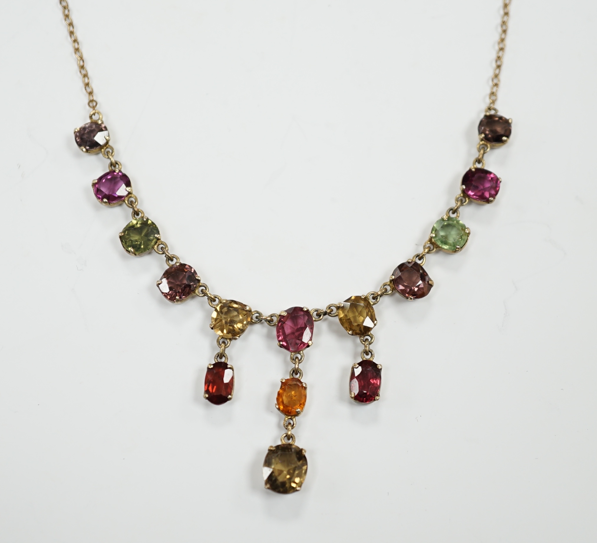 A yellow metal and multi gem set drop necklace, set with oval cut stones including tourmaline and hessonite garnet, 46cm, gross weight 6.6 grams.